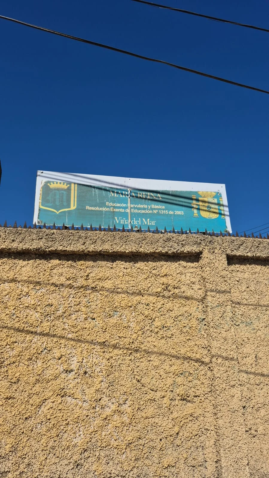 Letrero sobre muro perimetral — lona desprendida